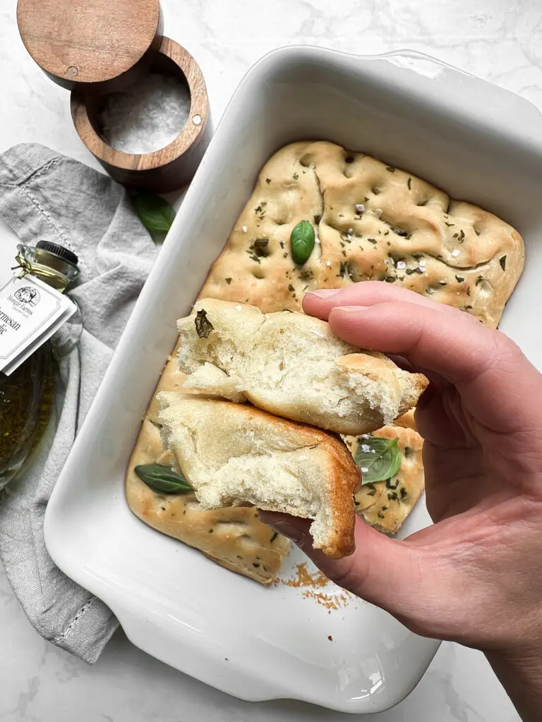 freshly baked, golden-brown Homemade Focaccia Bread garnished with rosemary and flaky sea salt.
