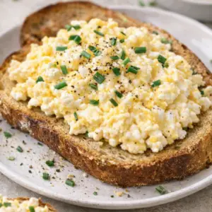 cottage cheese eggs- Creamy and Fluffy Cottage Cheese Eggs Creamy cottage cheese scrambled eggs on toasted bread topped with chives and black pepper, high-protein breakfast recipe