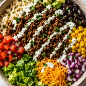 - Low-Cholesterol Ground Beef Burrito Bowl Recipe Low-cholesterol ground beef burrito bowl topped with cilantro lime brown rice, seasoned taco beef, black beans, corn, diced tomatoes, red onion, romaine lettuce, avocado, shredded cheddar cheese, and a creamy Greek yogurt drizzle.
