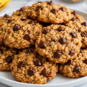 Stack of soft and chewy 3 ingredient oatmeal cookies with chocolate chips on a white plate.