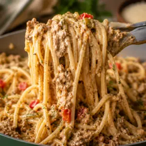 dirty spaghetti- Dirty Spaghetti (TikTok Viral Creamy Cajun Pasta) Close-up of creamy Dirty Spaghetti noodles being lifted from a sage green Caraway skillet, showing a rich Cajun Parmesan sauce coating every strand with seasoned beef and Italian sausage.